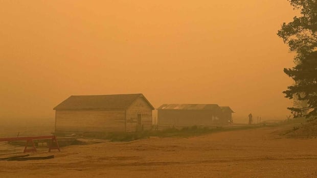 Orange smokey sky. A building is in the foreground
