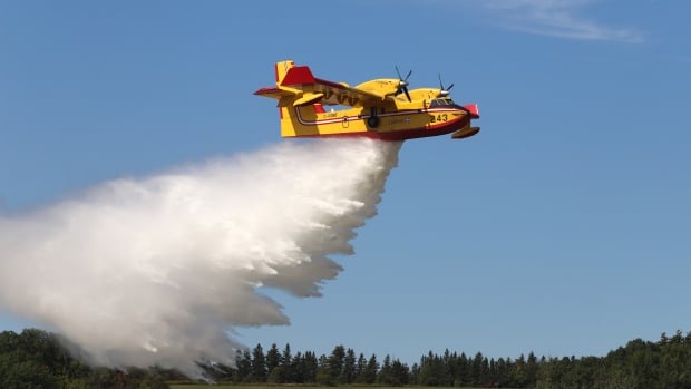 A water bomber dumps some water as it flies.