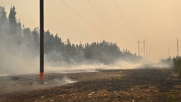 Smoke rises from a patch of burned ground.